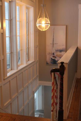 a hallway with a staircase with windows and a light fixture at The Hillside B&B. Home w/ Breakfast Service! in Wisconsin Dells