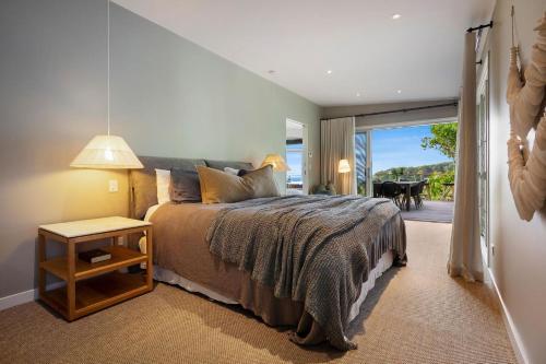 1 dormitorio con 1 cama y puerta que da a un patio en Elouera en Byron Bay