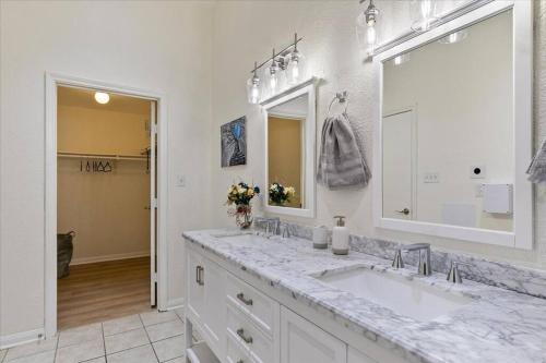 La salle de bains blanche est pourvue d'un lavabo et d'un miroir. dans l'établissement LUCKY House - Tranquility in the Middle of Houston - TV in every room - 300 m2, à Houston