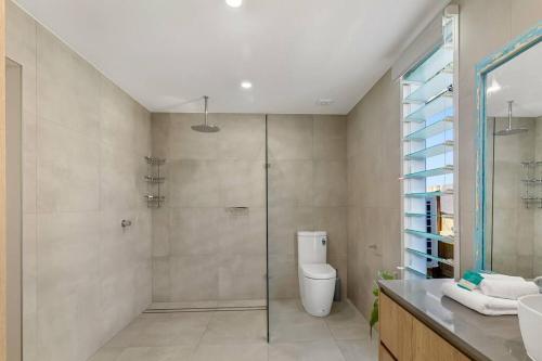a bathroom with a shower and a toilet and a sink at Luxury Coastal Retreat in Coolum Beach