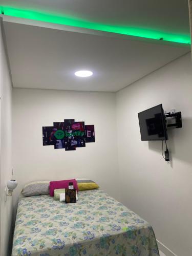 a bedroom with a bed and a tv on the wall at Mansão Digital in Brasilia