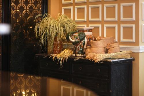 a black table with a vase and a plant on it at JM Marvel Hotel & Spa in Hanoi