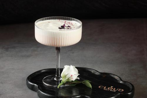 a wine glass with a flower on a black coaster at JM Marvel Hotel & Spa in Hanoi