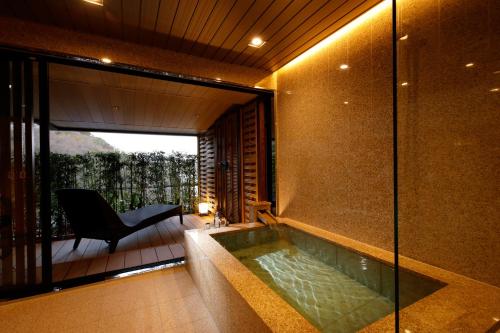 a swimming pool in a house with a chair at Kinzan in Kobe