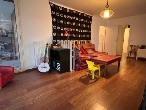 a living room with a couch and a table and a guitar at Spacious & cosy flat in Massy