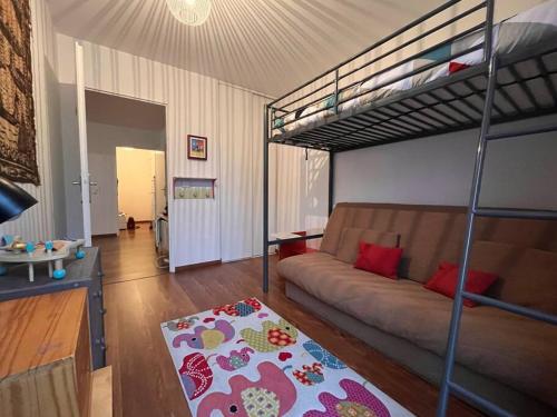 een woonkamer met een bank en een stapelbed bij Spacious & cosy flat in Massy