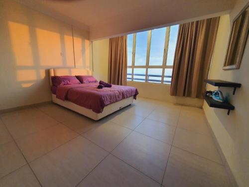 ein Schlafzimmer mit einem Bett und einem großen Fenster in der Unterkunft The Arena's Lavender @ Tanjung Tuan in Port Dickson
