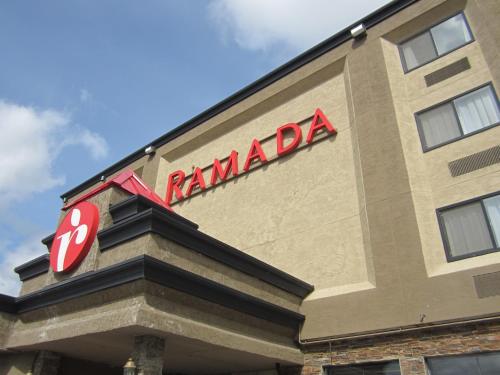 a ramada building with a red sign on it at Ramada by Wyndham Williams Lake in Williams Lake