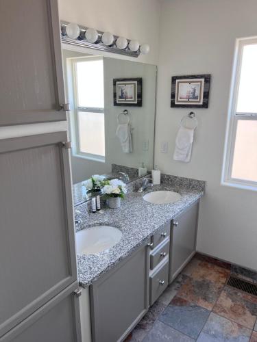 uma casa de banho com 2 lavatórios e um espelho em Spacious, comfortable & relaxing home 4 em Las Cruces
