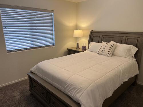 a bedroom with a large white bed with a window at Spacious, comfortable & relaxing home 4 in Las Cruces