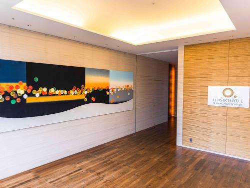 a lobby with a large painting on the wall at LOISIR HOTEL SHINAGAWA SEASIDE in Tokyo