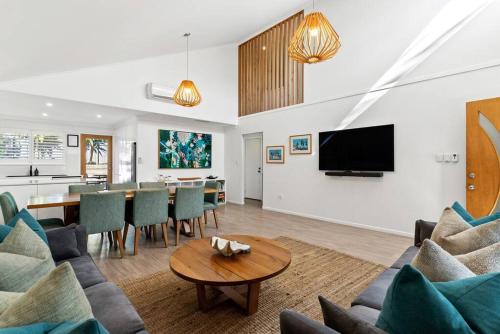 a living room with a couch and a table at Fuller Holidays - Somerset@Byron in Byron Bay