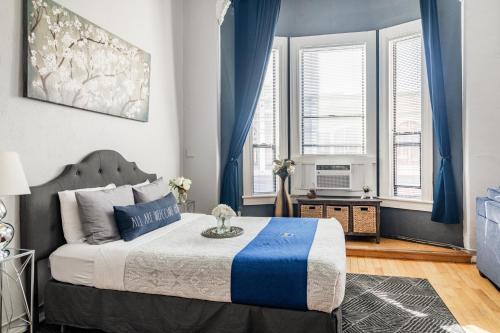 a bedroom with a bed with blue curtains and a television at Greely Gaslamp - Loft W Parking & 3 Beds #202 in San Diego