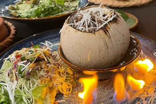 a plate of food with a ball on top of a salad at JM Marvel Hotel & Spa in Hanoi