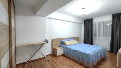 a small bedroom with a bed and a window at Brown Aparts in Chişinău
