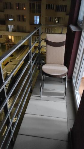 a chair sitting on the balcony of a building at Brown Aparts in Chişinău