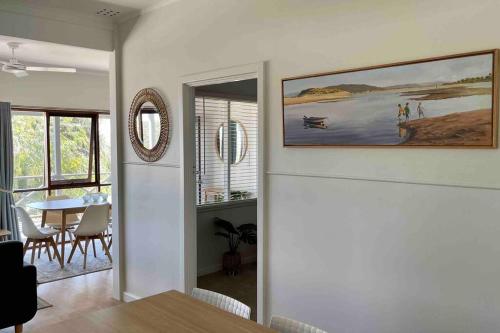 a living room with a table and a painting on the wall at Moore to Sea~Spectacular views in stylish comfort in Guilderton