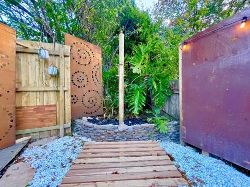 a garden with a wooden fence and a wooden walkway at Frankie the Silver Bullet Airstream in Katoomba