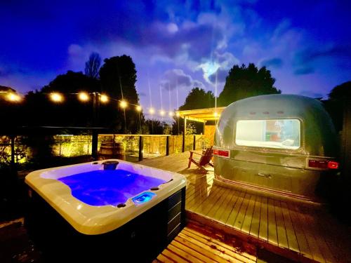 a large hot tub sitting on a deck next to a rv at Frankie the Silver Bullet Airstream in Katoomba