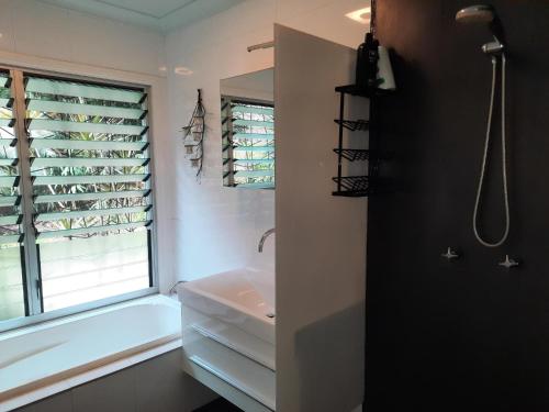 een badkamer met een wastafel en een raam bij Daintree Rainforest Accommodation in Cow Bay