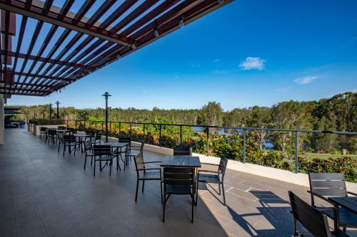 a row of tables and chairs on a patio at Mercure Kooindah Waters Central Coast in Wyong