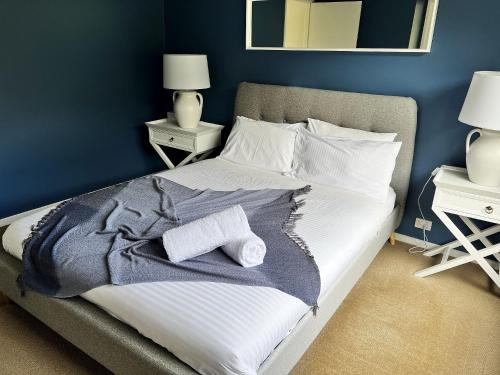 a bedroom with a bed with a blue wall at McMillans of Metung Coastal Resort in Metung