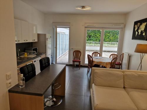une cuisine et un salon avec un canapé et une table dans l'établissement Entier beau 3pièces avec terrasse de 60m2 pour 7personnes, à Châtenay-Malabry