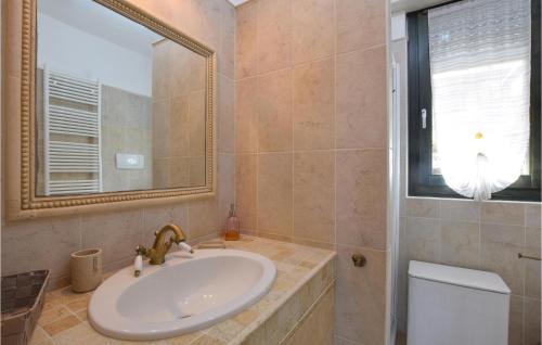 ein Badezimmer mit einem Waschbecken, einem Spiegel und einem WC in der Unterkunft Appartamento Helios in Baveno