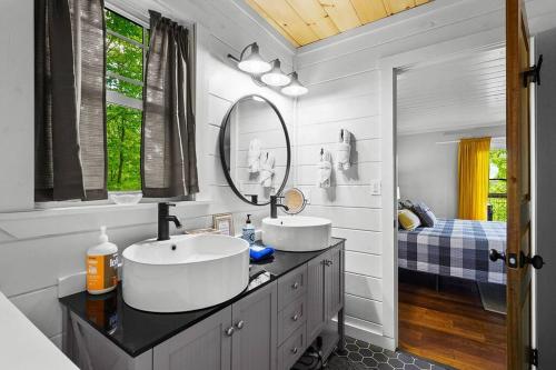 a bathroom with two sinks and a mirror at Chic private cabin w/ epic views & amenities! in Cove Creek Cascades