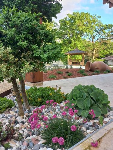a garden with flowers and a tree and a gazebo at La petite maison dans le Quercy in Cayriech