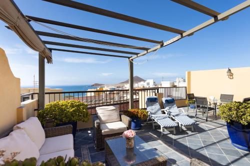 een patio met stoelen en een tafel en de oceaan bij 106 Medano Perfect Seaviews By Sunkeyrents in El Médano