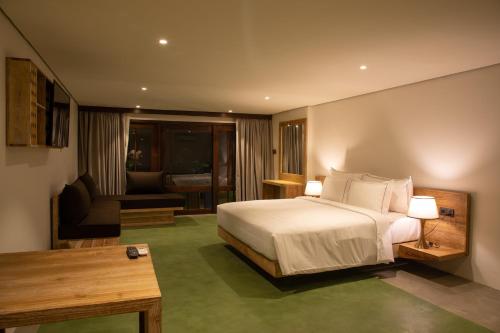 Lake Avenue Hotel Kandy في كاندي: غرفه فندقيه بسرير واريكه