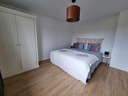 een slaapkamer met een groot bed en een houten vloer bij Horsea 