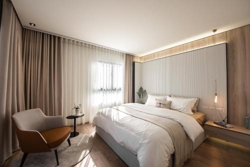 um quarto de hotel com uma cama e uma cadeira em WiSmart em Taichung