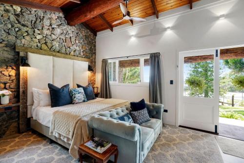 a bedroom with a bed and a stone wall at Maleny Country Estate in Maleny