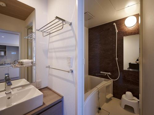 a bathroom with a sink and a shower at HOTEL R9 The Yard Kaizu in Kaizu