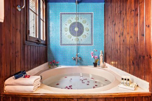 y baño con bañera grande con azulejos azules. en Sweet Inn - Ethnic Eixample, en Barcelona
