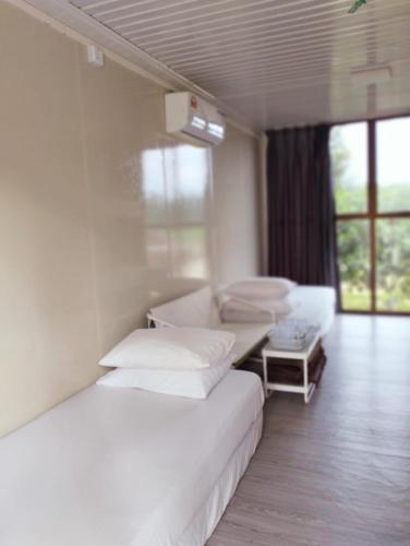 Zimmer mit 2 Betten, einem Sofa und einem Fenster in der Unterkunft CABIN SARAWAK D' RUMAH BONDA RIVER VIEW in Kampong Senawar