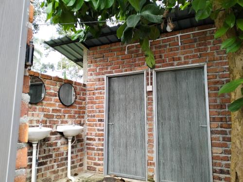 ein Backsteinhaus mit zwei Türen und zwei Waschbecken in der Unterkunft CABIN SARAWAK D' RUMAH BONDA RIVER VIEW in Kampong Senawar