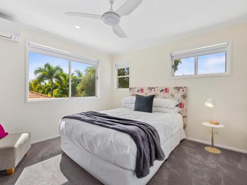 een witte slaapkamer met een bed en een raam bij Parkside Noosa River in Noosaville