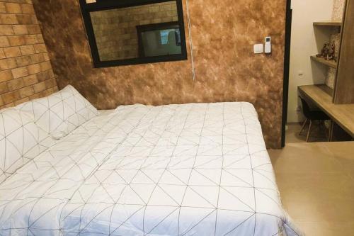 a bedroom with a white bed with a mirror on the wall at Freja House @ Central BSD in Samporo