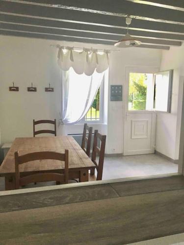 une salle à manger avec une table et des chaises et une fenêtre dans l'établissement Cottage de charme à la campagne, à Aulnoy