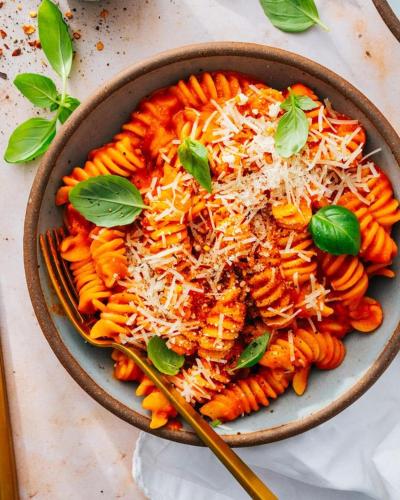 デヘラードゥーンにあるStartup Houseのテーブルの上にチーズとバジルを添えたパスタのボウル