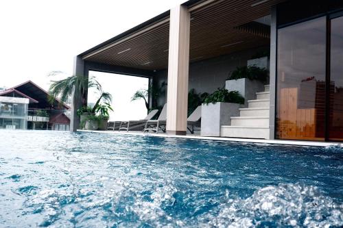 a swimming pool in front of a house at D'Lecia Ha Long Hotel in Ha Long