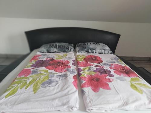 バラトンアカリにあるHóvirág Vendégházのベッドの上に枕2つ(花付)