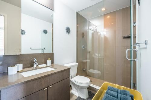 y baño con lavabo, aseo y ducha. en Modern Lillian St Apartments by GLOBALSTAY, en Toronto