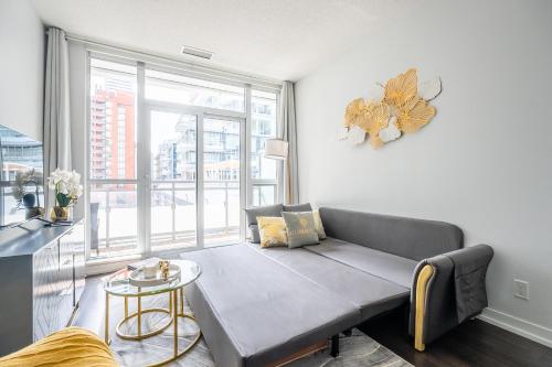 a living room with a couch and a large window at Modern Lillian St Apartments by GLOBALSTAY in Toronto