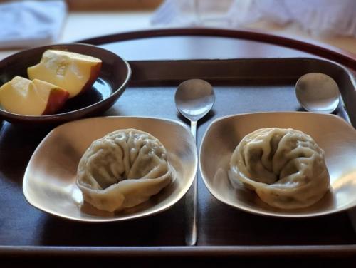 een dienblad met twee borden knoedels op een tafel bij Tohyang Traditional House in Bonghwa