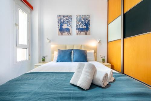 a bedroom with a large bed with blue pillows at WintoWinRentals La Malagueta Buena ubicación, Wifi in Málaga