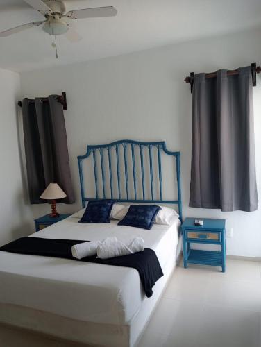 a bedroom with a blue and white bed and a window at Magnifico Departamento, cocina equipada, 2 Recamaras 2 Baños , hasta 6 Personas, 3 albercas, playa a 50 mts wifi, aire acondicionado in Manzanillo